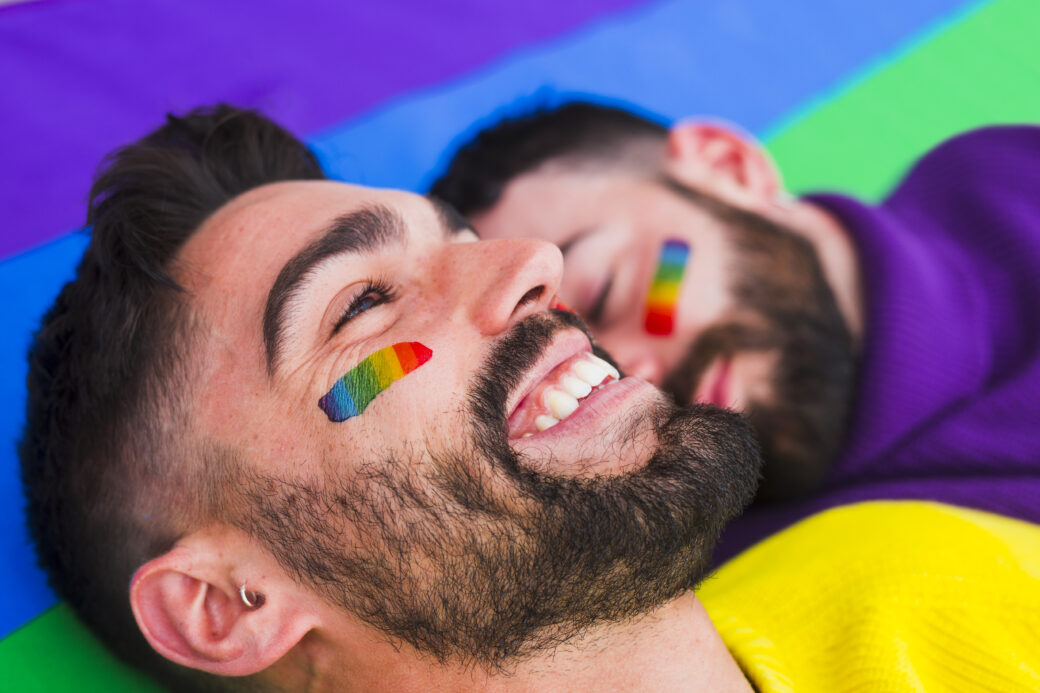 cheerful homosexual with partner rainbow flag