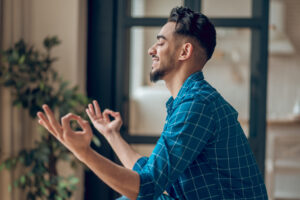 positive young yogi sitting lotus pose with fingers giana mudra