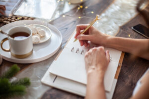 Articles 3 young woman writing plans goals new year while her daughter crafting christmas trees