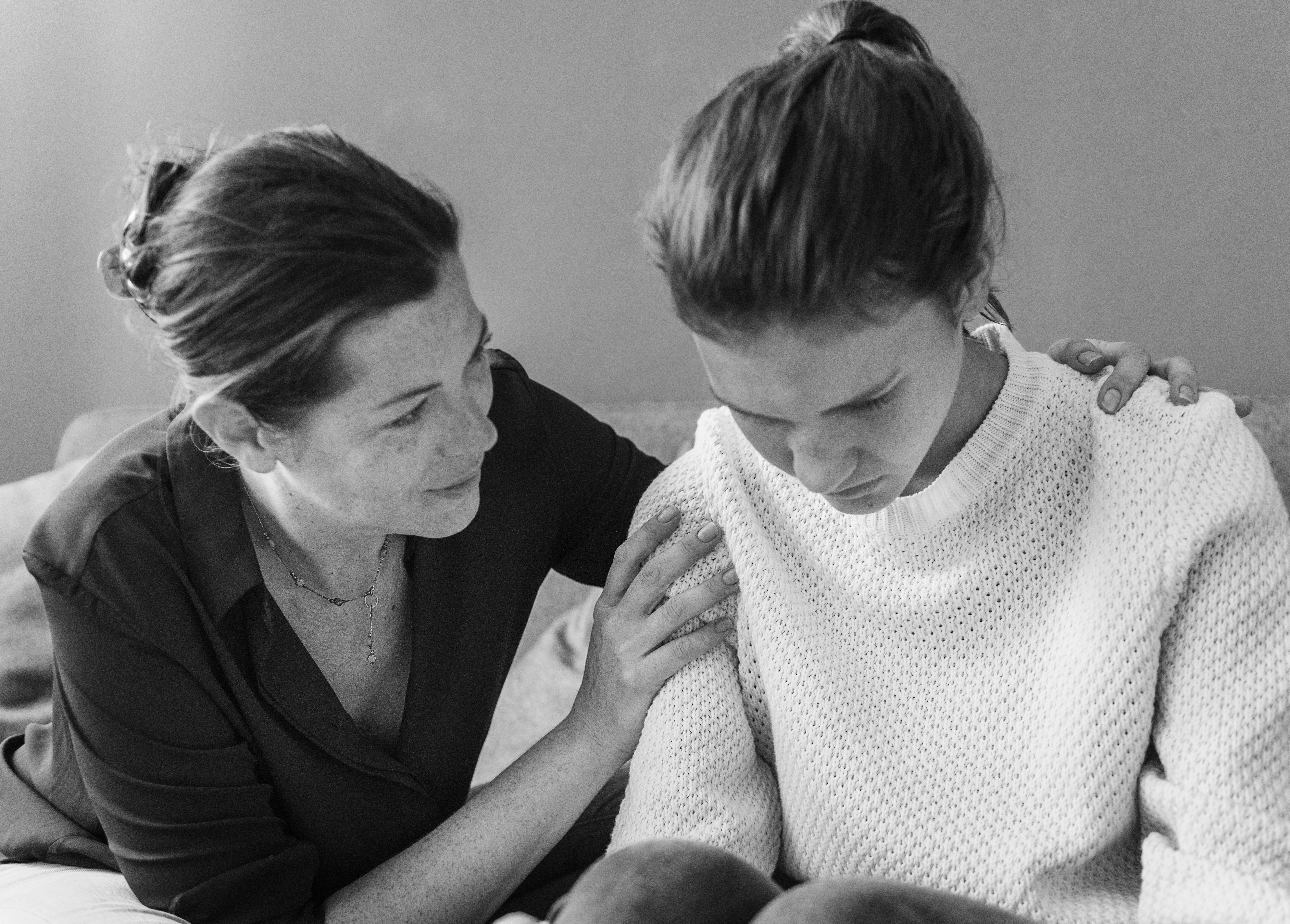 mother consoling her sad daughter